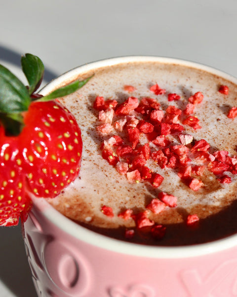 Tasse avec morceaux de fraises dans un breuvage de chocolat chaud